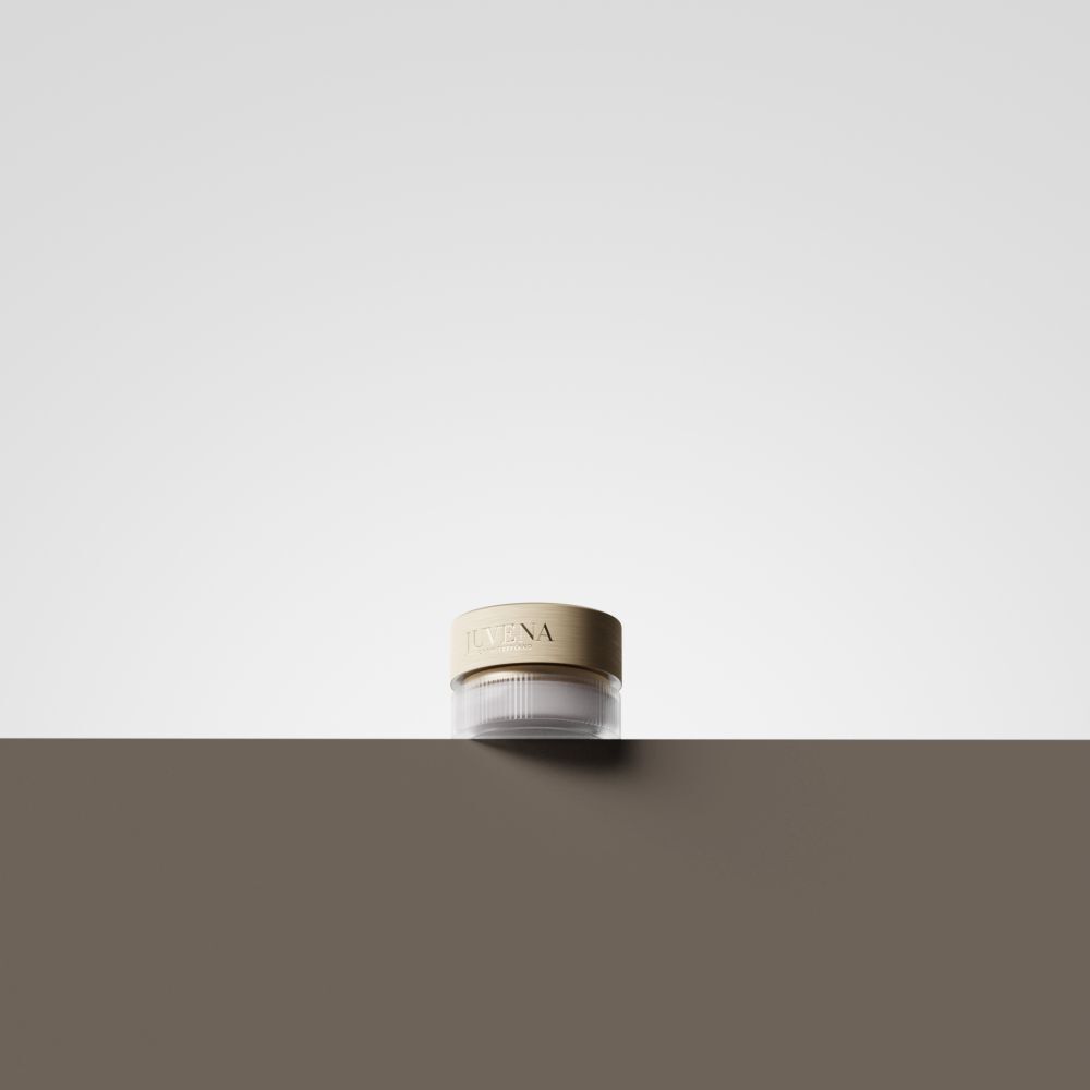 Crèmepot met goudkleurig deksel. Opschrift: JUVENA. De pot staat op een bruin oppervlak.