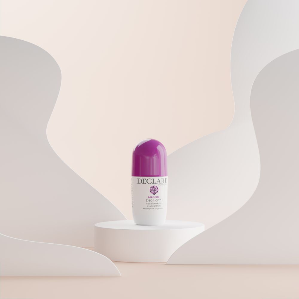 Roll-on Deo Forte sur socle blanc. Fond : formes abstraites beige et blanc. Bouchon violet visible.