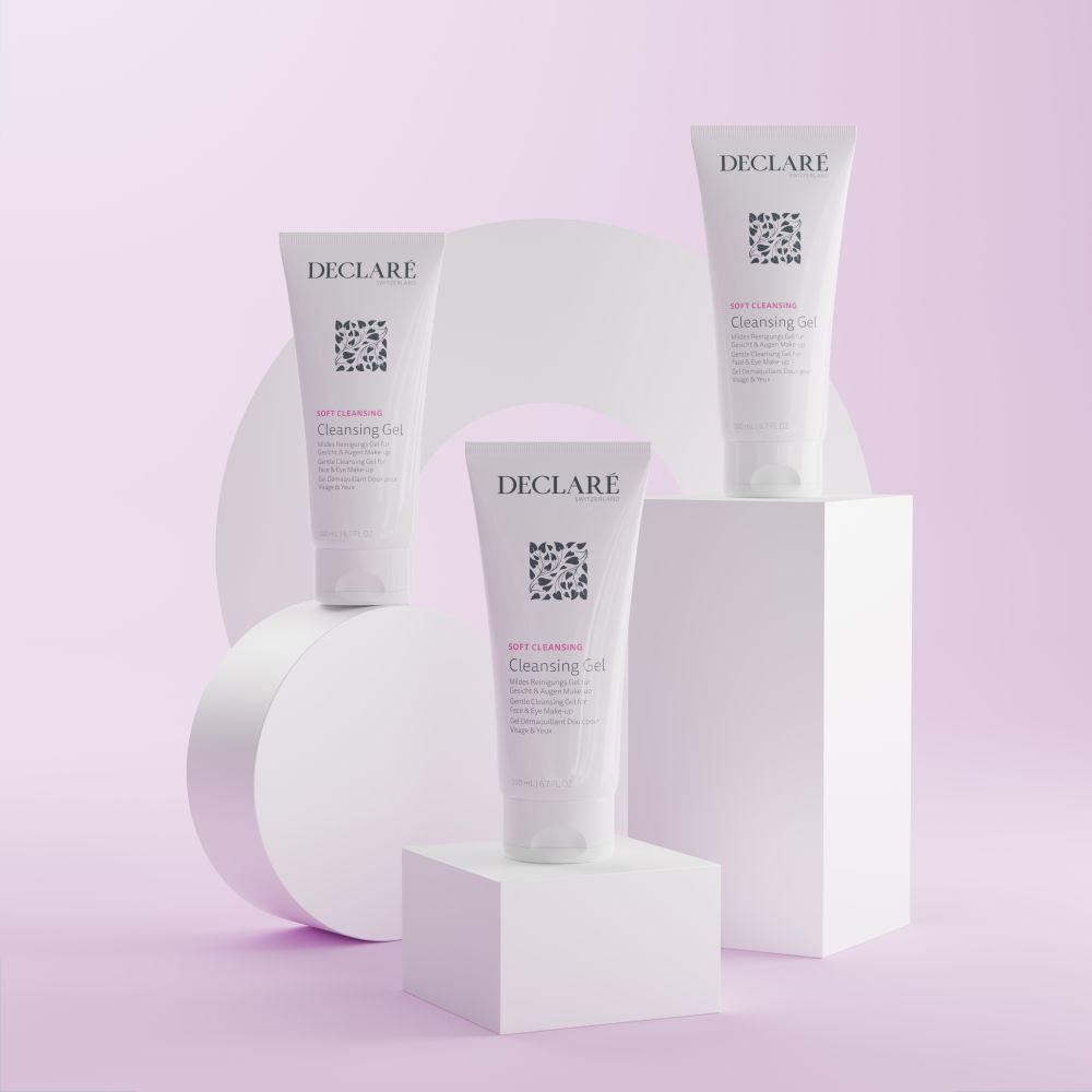 Drie witte tubes DECLARÉ Cleansing Gel op voetstukken. Achtergrond: geometrische vormen in pasteltinten.
