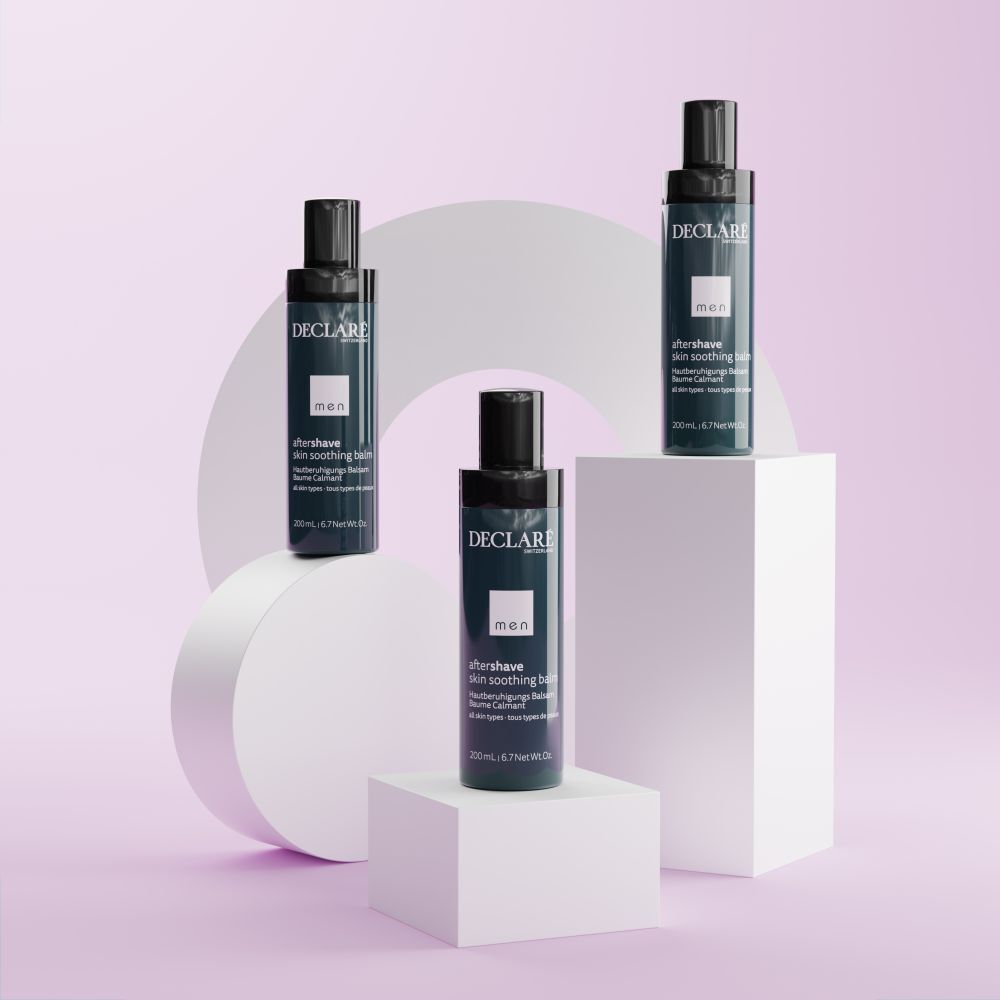Trois flacons DECLARÉ Men Baume après-rasage. Bleu et noir. Texte : aftershave skin soothing balm. Sur socles.