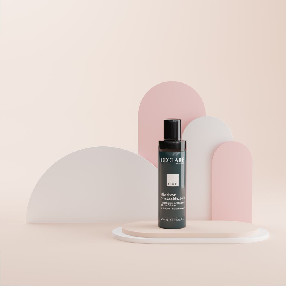 Un flacon DECLARÉ Men Baume après-rasage. Bleu et noir. Texte : aftershave skin soothing balm. Sur socle.