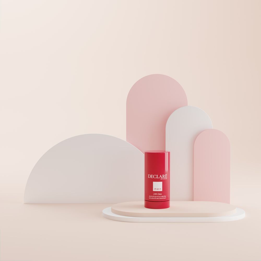 Déodorant rouge sur un socle. Fond avec formes roses et blanches.