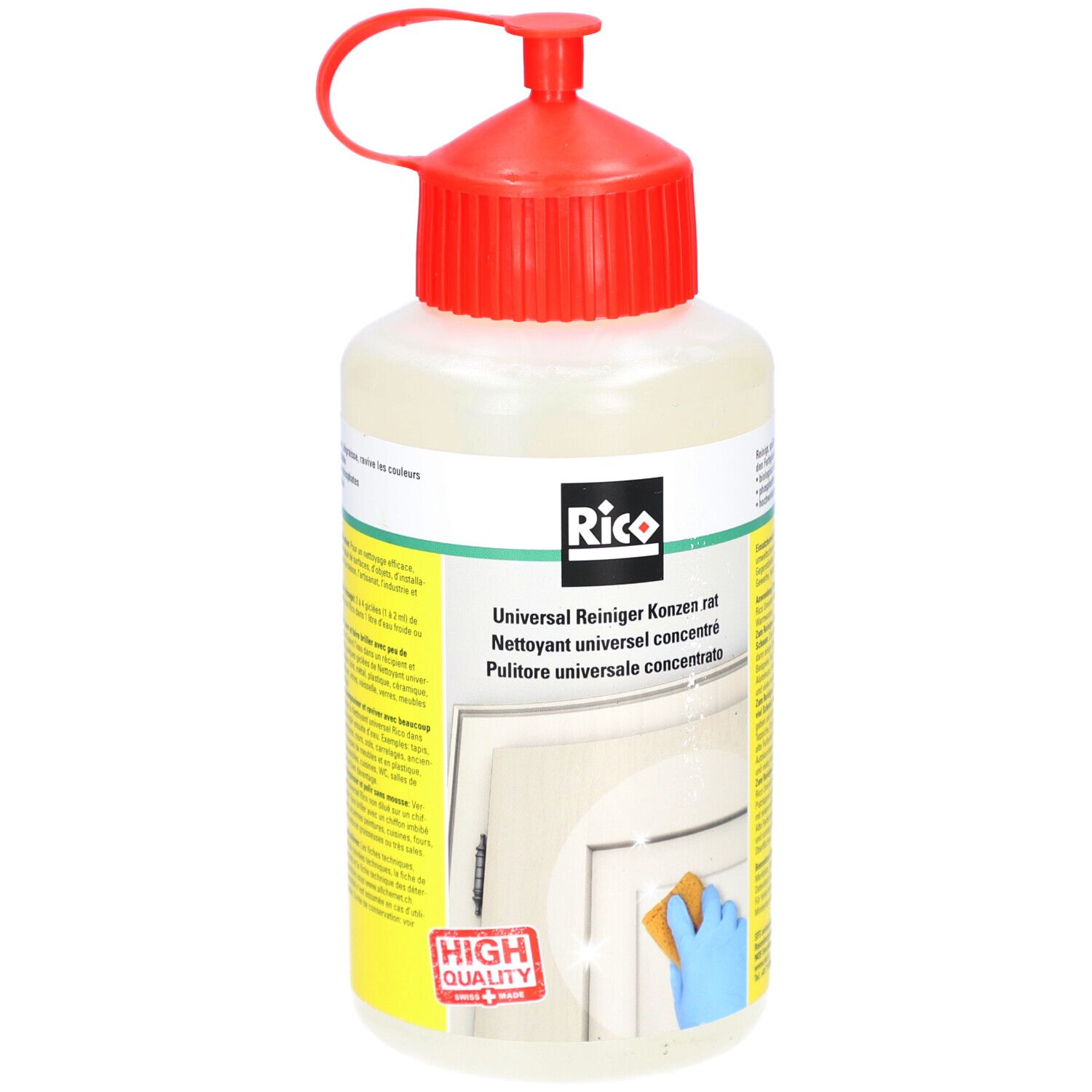 Fles met rode dop. Opschrift: Rico, Universalreiniger concentraat. Gele en witte etiketten. Spons en deur op de achtergrond.