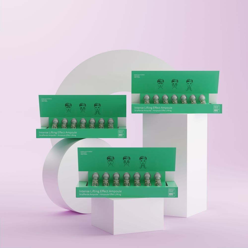 Trois boîtes vertes avec ampoules. Inscription: Intense Lifting Effect Ampoule. Sur fond rose et blanc.