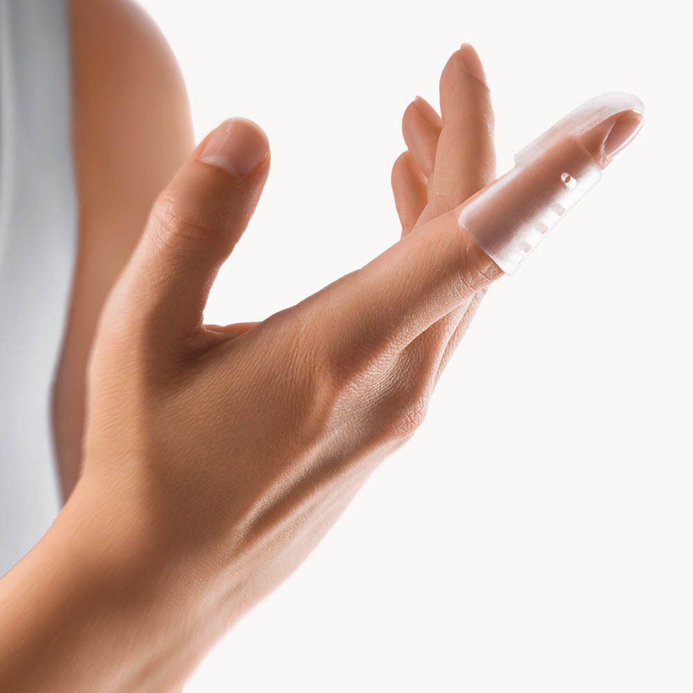 Transparante vingerorthese op een vinger. De spalk bedekt de vinger tot aan het eerste gewricht.