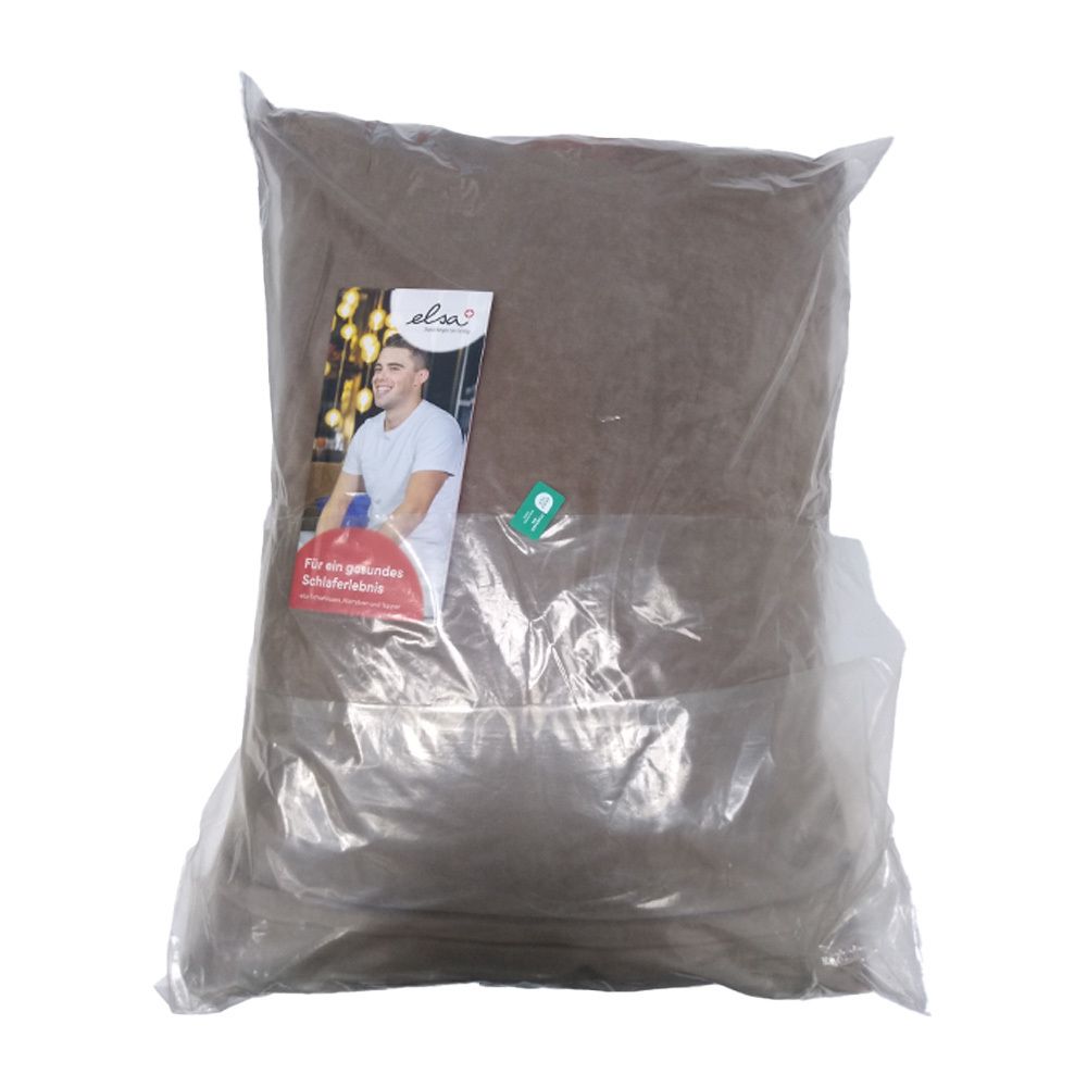 Kussen in transparante verpakking. Label met logo en afbeelding van een man. Tekst in het Duits.