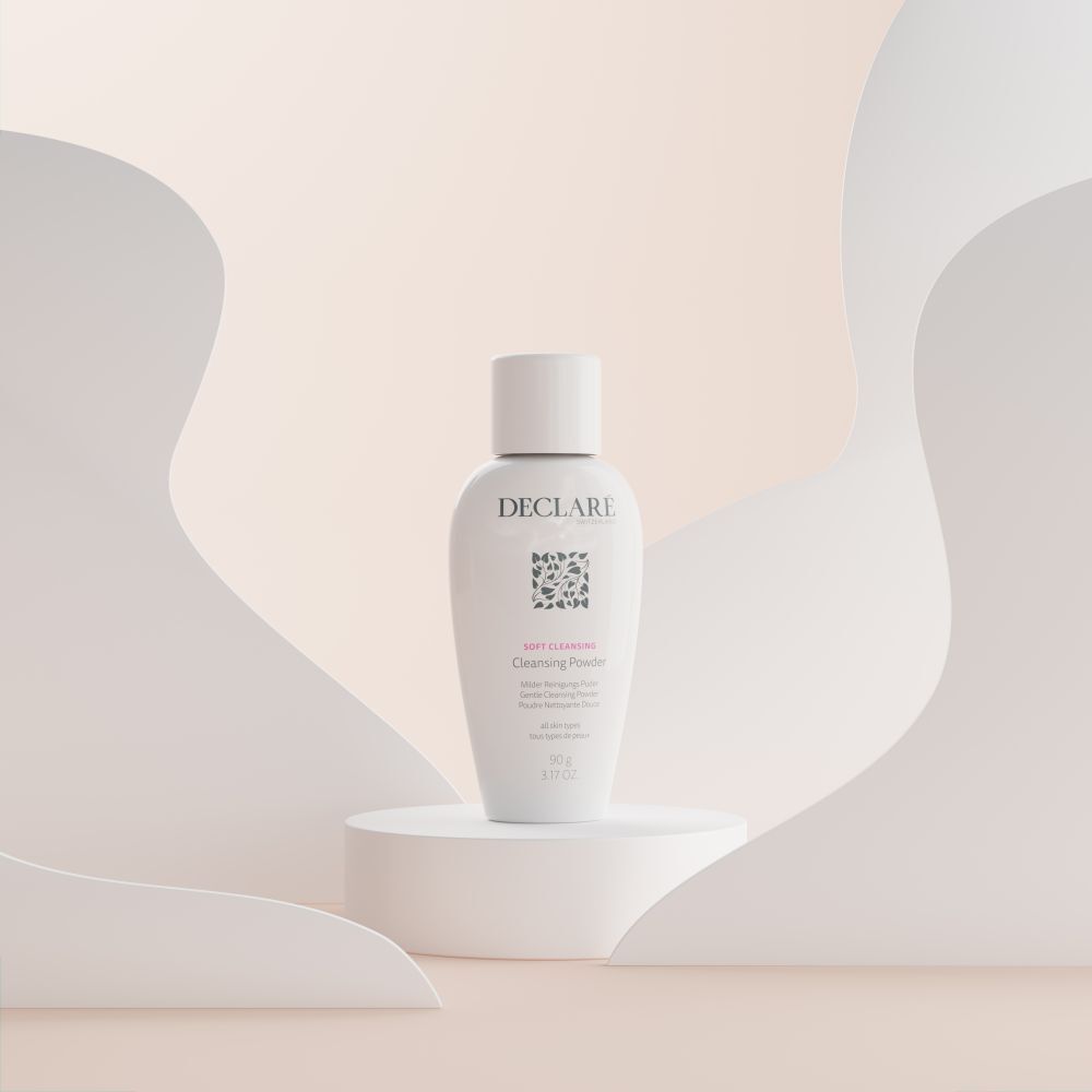 DECLARÉ Soft Cleansing Poudre op sokkel. Wit product, logo, naam, informatie. Achtergrond met vormen.