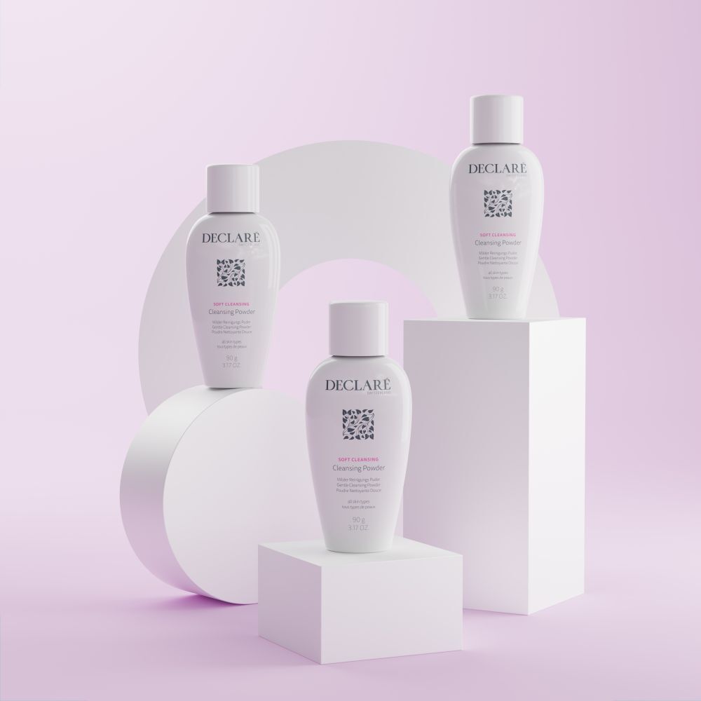 Drie DECLARÉ Soft Cleansing Poudre op sokkels. Wit product, logo, naam, informatie. Achtergrond met vormen.