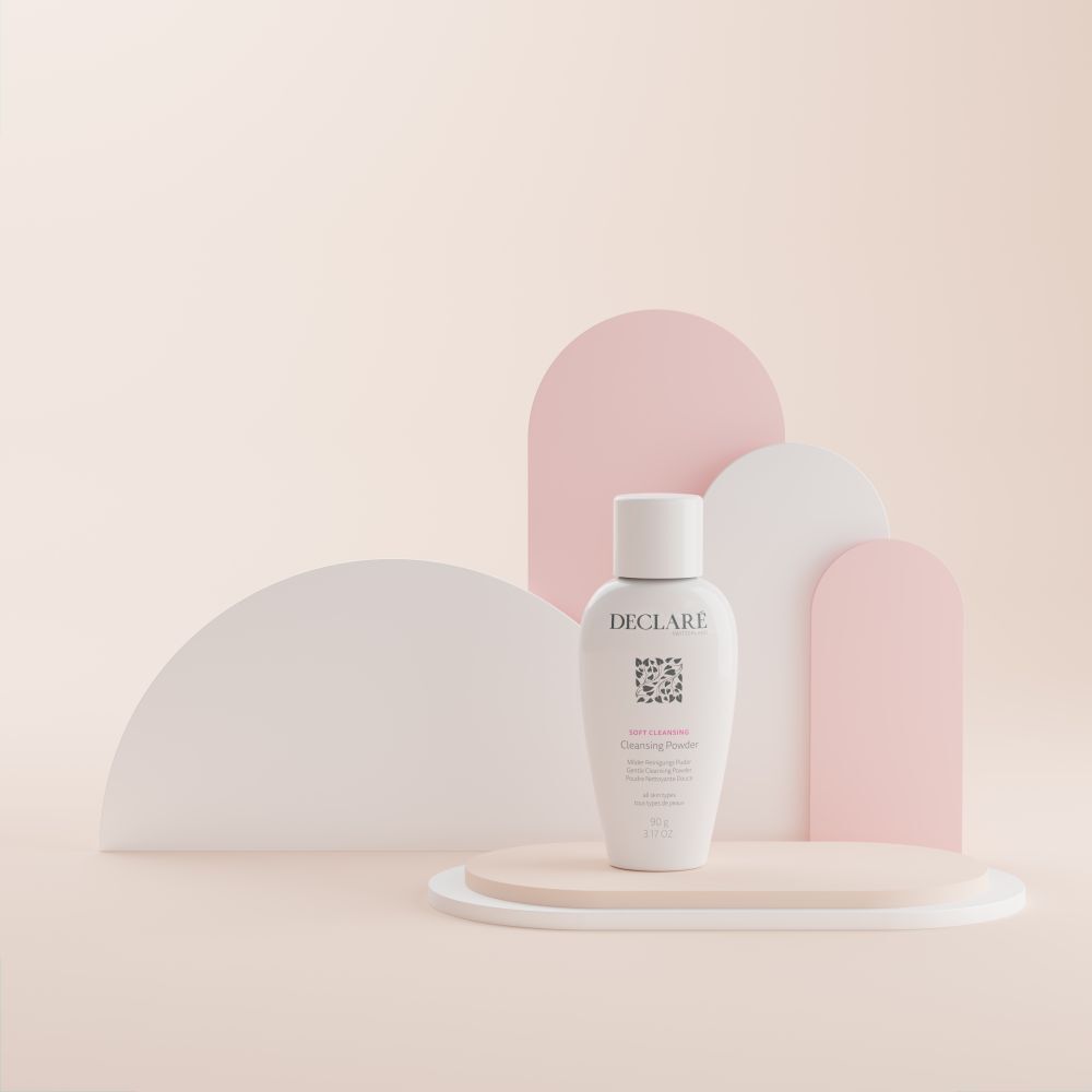 DECLARÉ Soft Cleansing Poudre op sokkel. Wit product, logo, naam, informatie. Achtergrond met vormen.