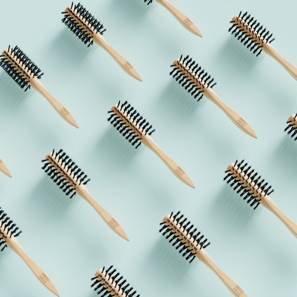 Patroon van ronde haarborstels op lichtblauwe achtergrond. Houten handvat, zwarte borstelharen.