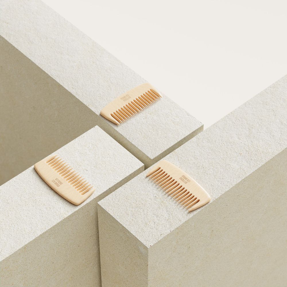 Drie houten kammen op witte blokken. Op elke kam staat "Marlies Möller".