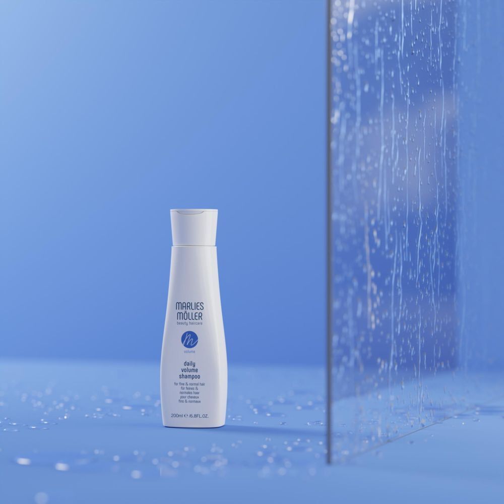 Flacon de shampooing blanc sur fond bleu. Inscription: Marlies Möller, Volume Daily Volume Shampoo. 200ml.