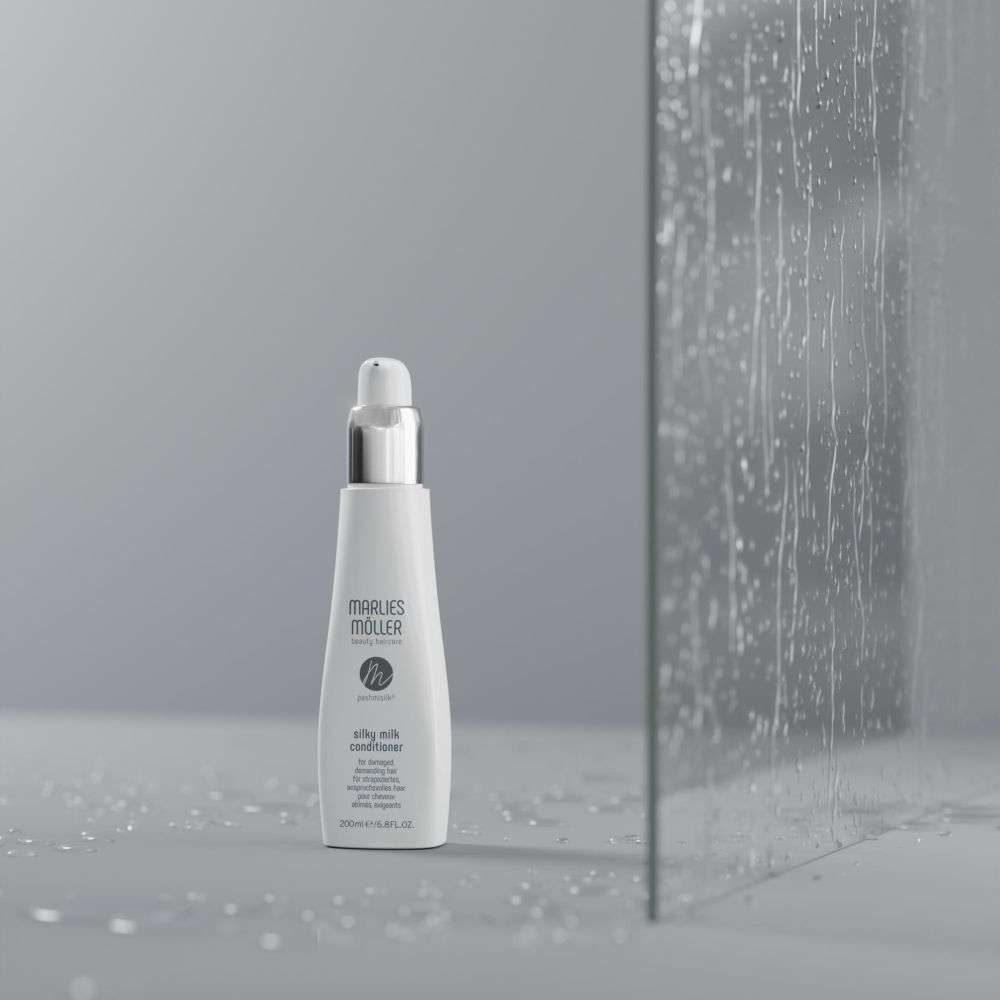 Flacon devant une paroi vitrée. Flacon: blanc, bouchon argenté. Inscription: Marlies Möller, Silky Milk Conditioner.