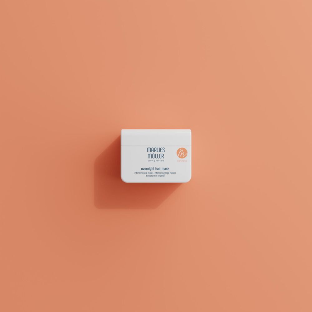 Contenant blanc Marlies Möller Overnight Hair Mask, sur fond orange. Vue de dessus.