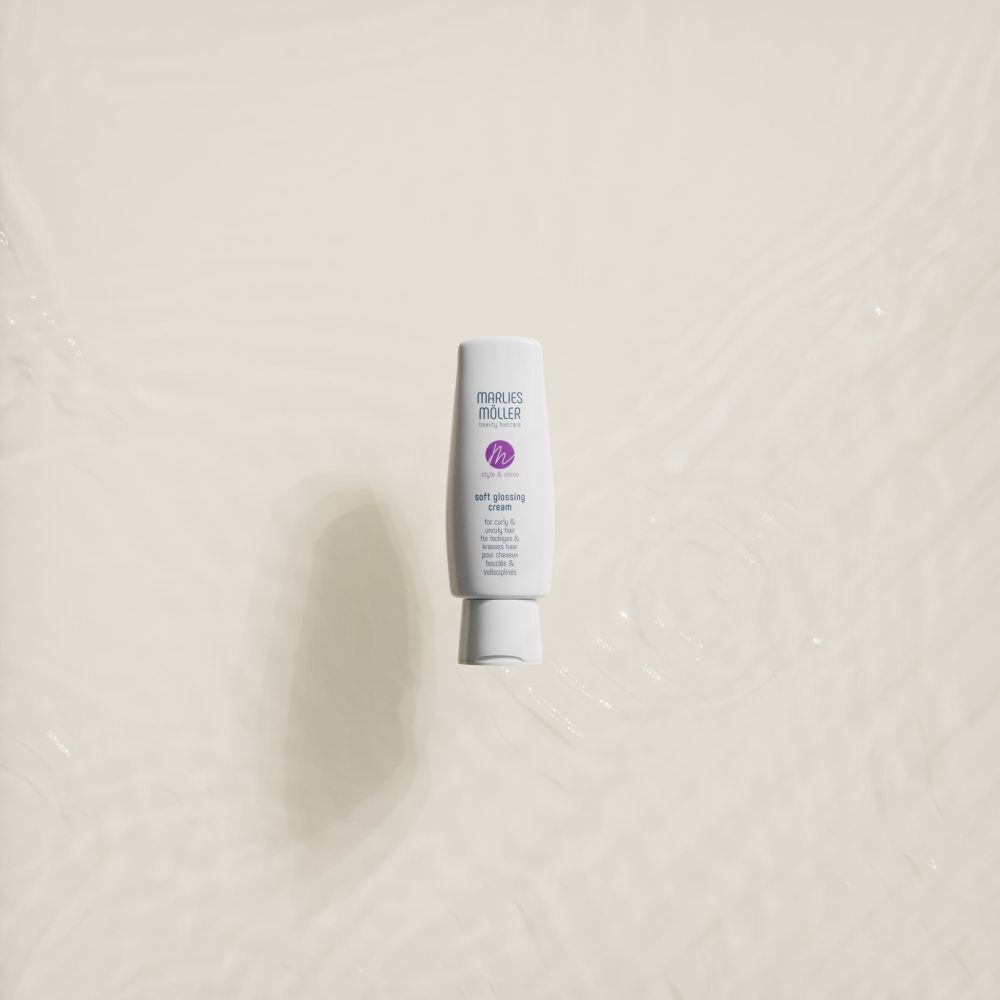Witte tube, Marlies Möller Soft Glossing Cream, op lichte achtergrond. Product lijkt in water te zweven.