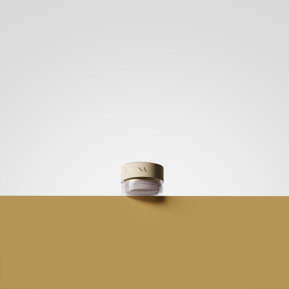 Pot de crème avec couvercle doré. Inscription: JUVENA. Placé sur un fond doré.