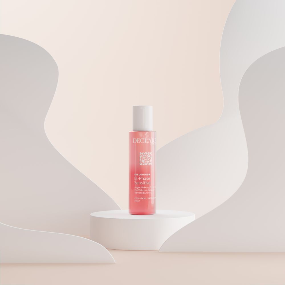 Produit sur socle. Liquide rose en flacon avec bouchon blanc. Texte: DECLARE, EYE CONTOUR, Bi-Phase Sensitive.
