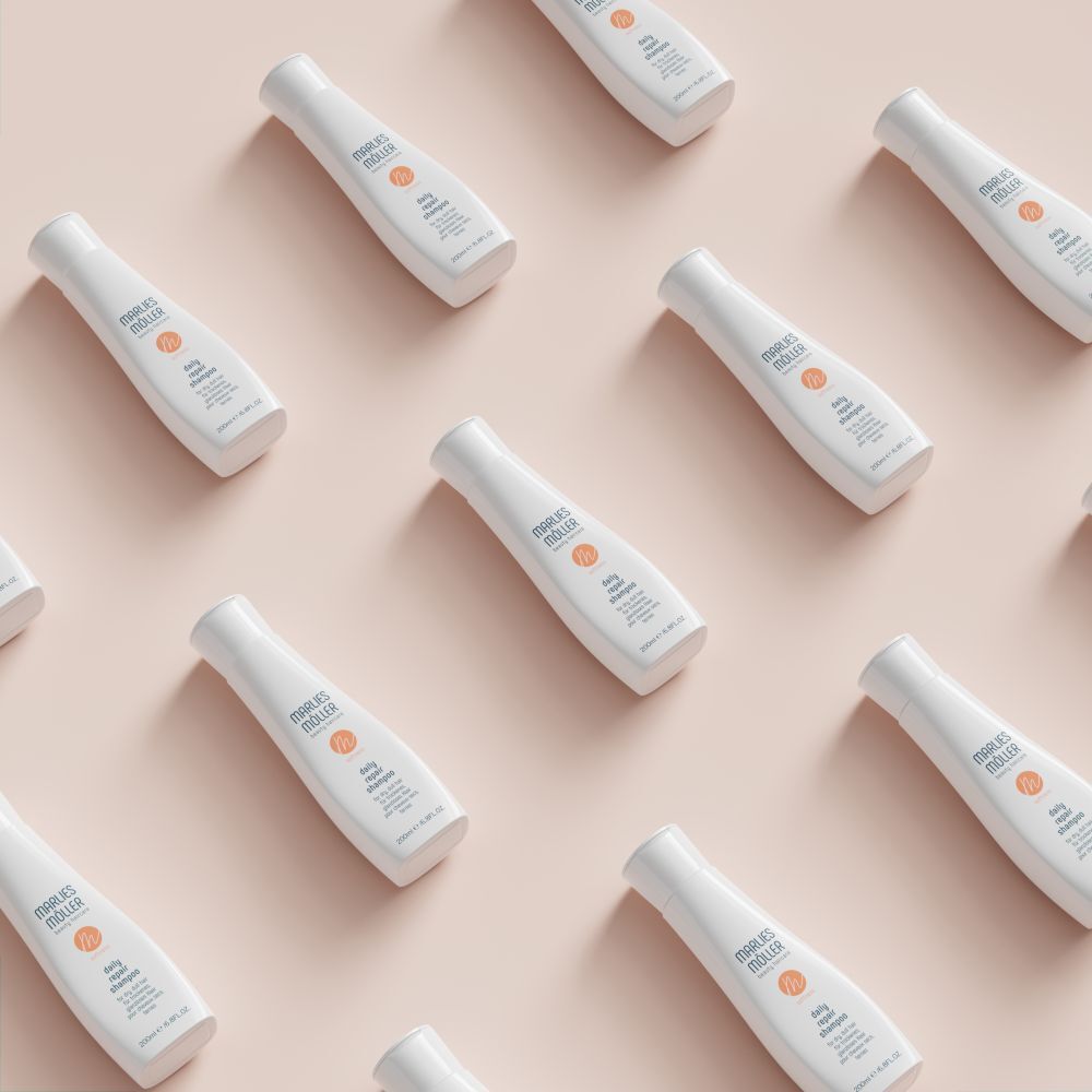 Plusieurs flacons de shampooing blancs sur fond rose. Inscription: Marlies Müller, daily repair shampoo. 200ml/6.8FL.OZ.