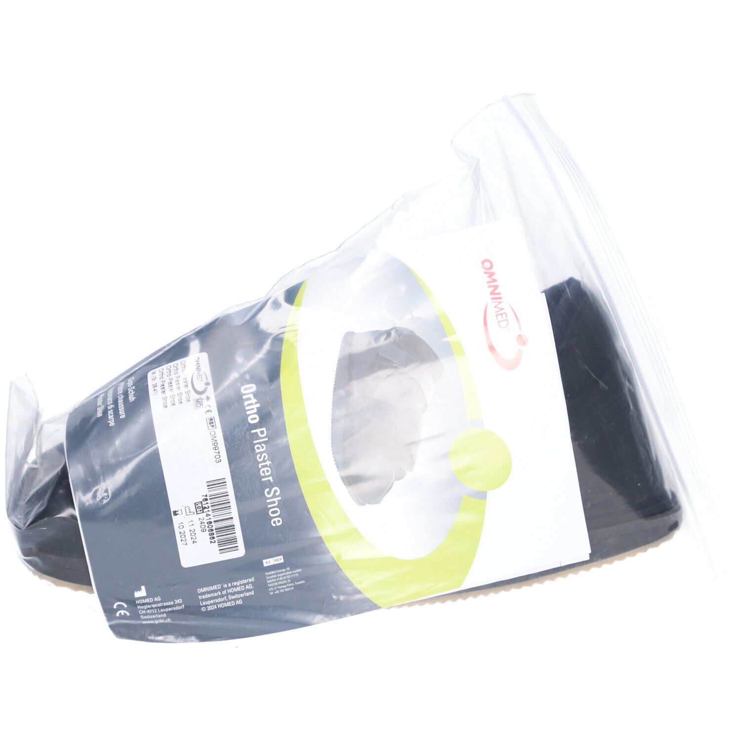 Chaussure de plâtre Ortho dans un emballage plastique. Étiquette avec informations produit. Logo OMNIMED visible.