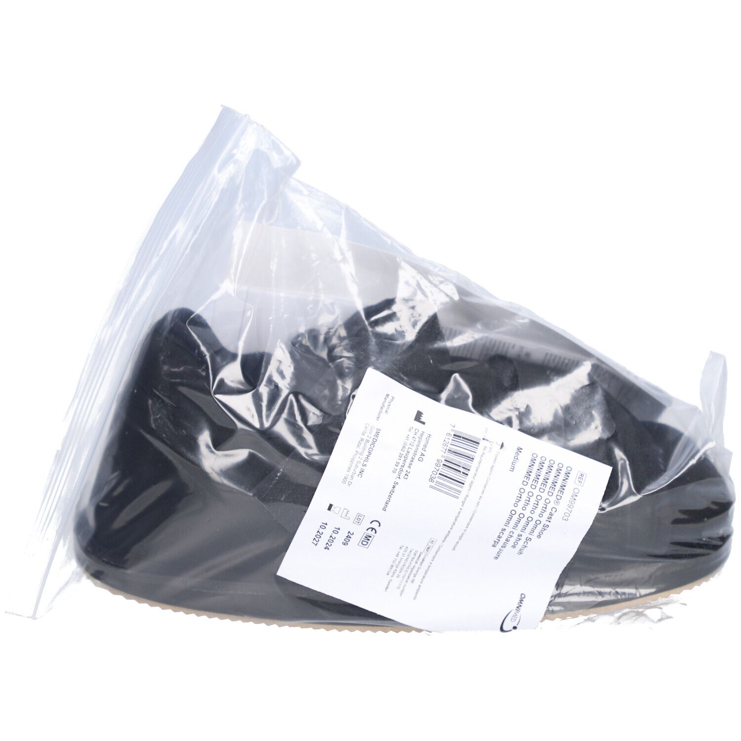 Chaussure de plâtre Ortho noire dans un emballage plastique. Étiquette avec informations produit. Marquage CE.