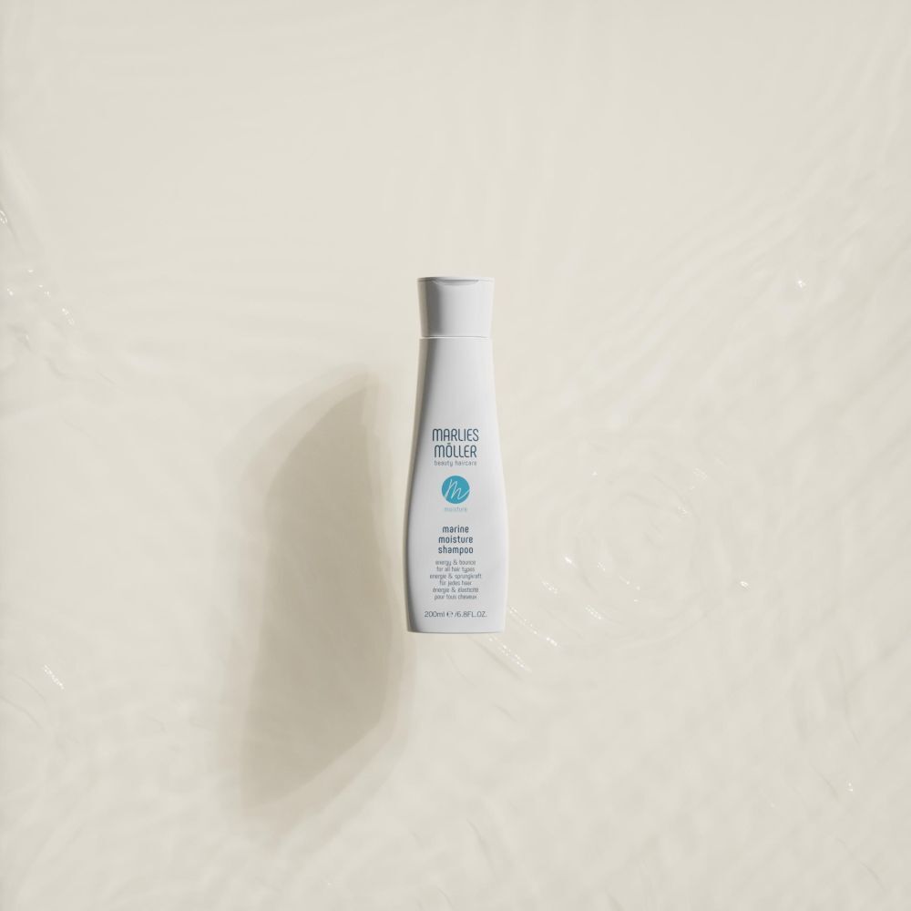 Witte shampoo fles op crème achtergrond. Opschrift: Marlies Möller, Marine Moisture Shampoo.