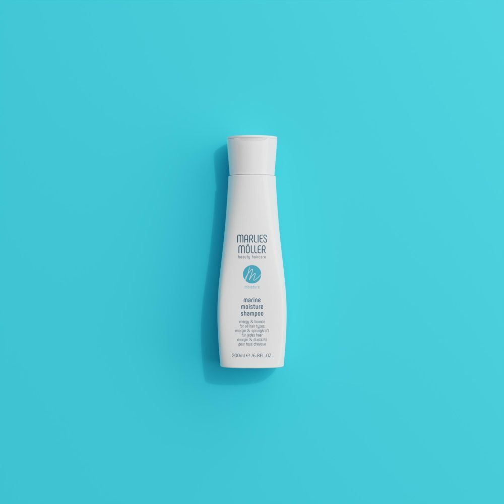 Shampoo fles op blauwe achtergrond. Opschrift: Marlies Möller, Marine Moisture Shampoo.