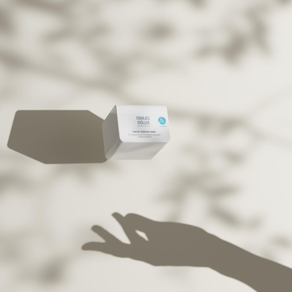 Witte pot met schaduw. Marlies Möller Marine Moisture Mask. Hand in schaduw.