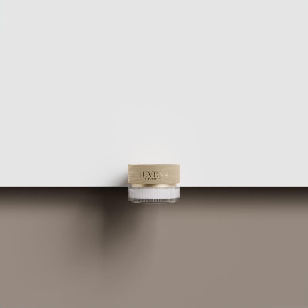 Crèmepot met gouden deksel. Op bruin oppervlak. Witte achtergrond.