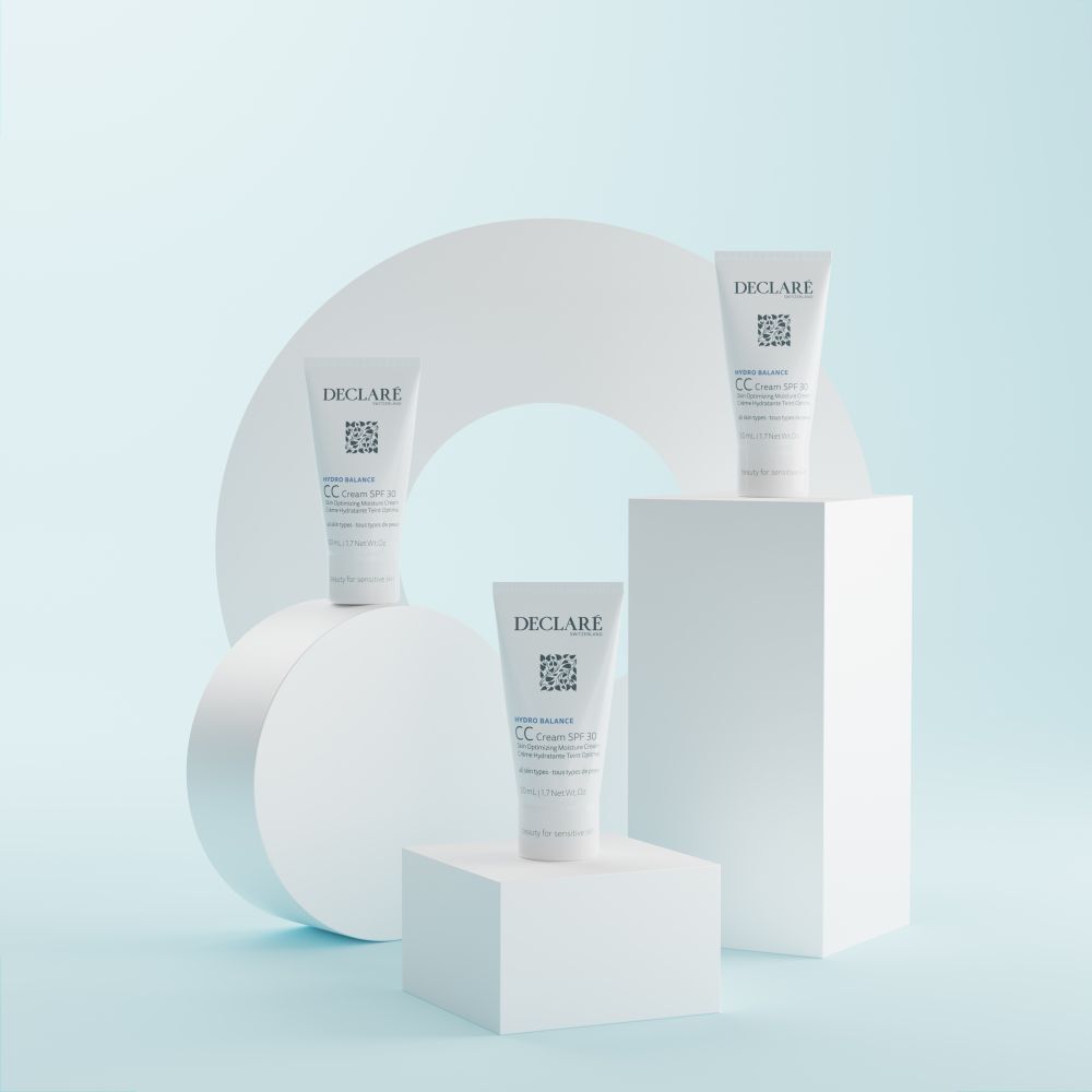 Drie tubes DECLARÉ CC Cream SPF 30 op witte blokken. Achtergrond met witte cirkel.