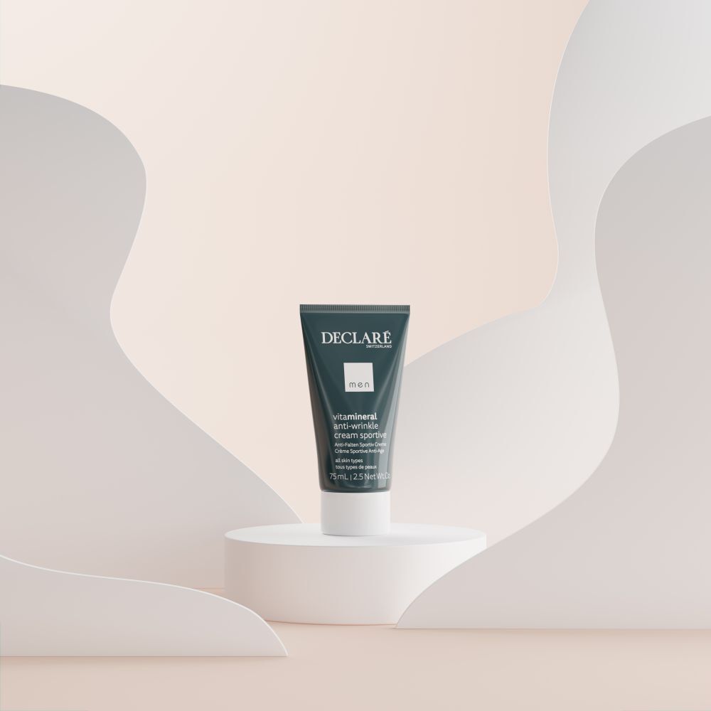 Declare anti-rimpelcrèmetube op wit voetstuk. Achtergrond met abstracte vormen in pasteltinten.