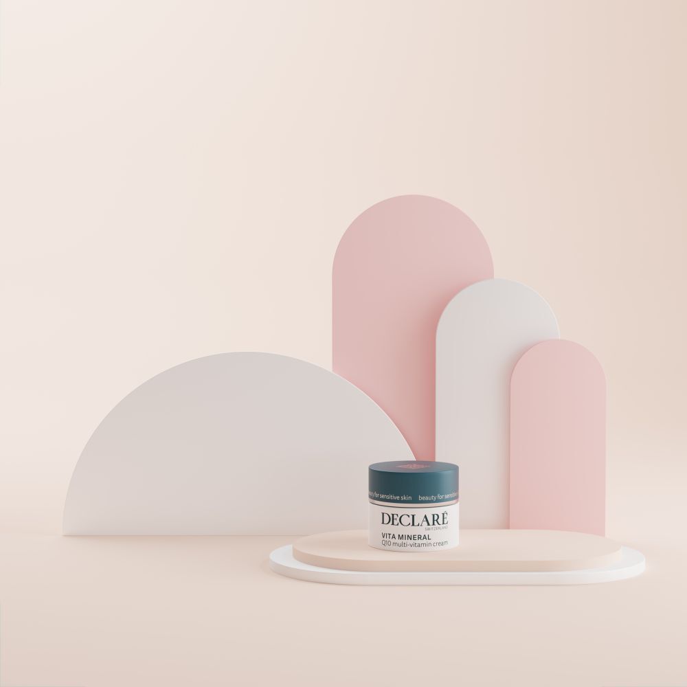 Crèmepot op voetstuk. DECLARÉ Vita Mineral Q10 Multi-Vitamin Crème. Achtergrond met vormen.