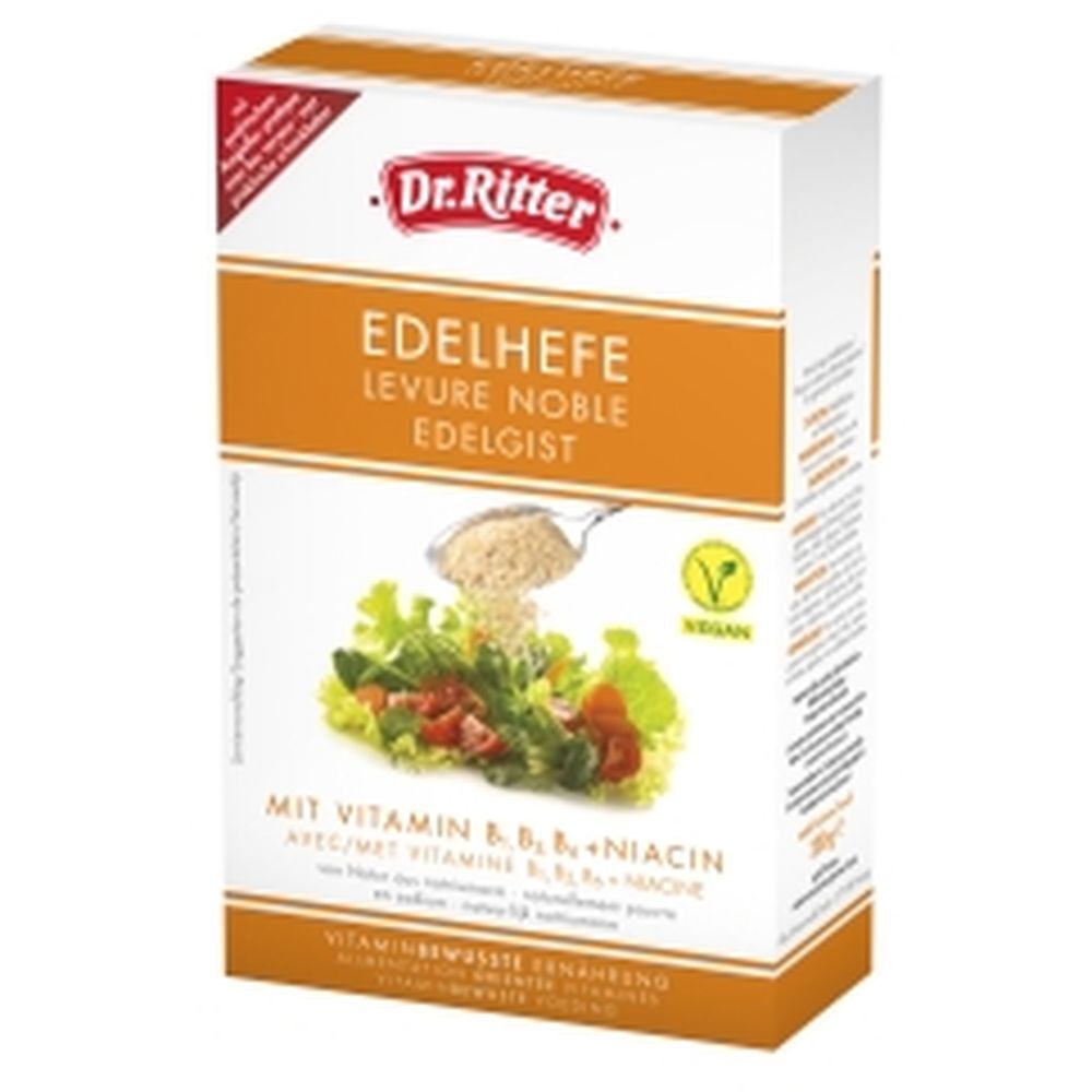 Verpakking van Dr. Ritter Edelhefe vlokken. Opschrift: Edelgist, Vegan-zegel, vitamine B-complex. Afbeelding: Salade met vlokken.