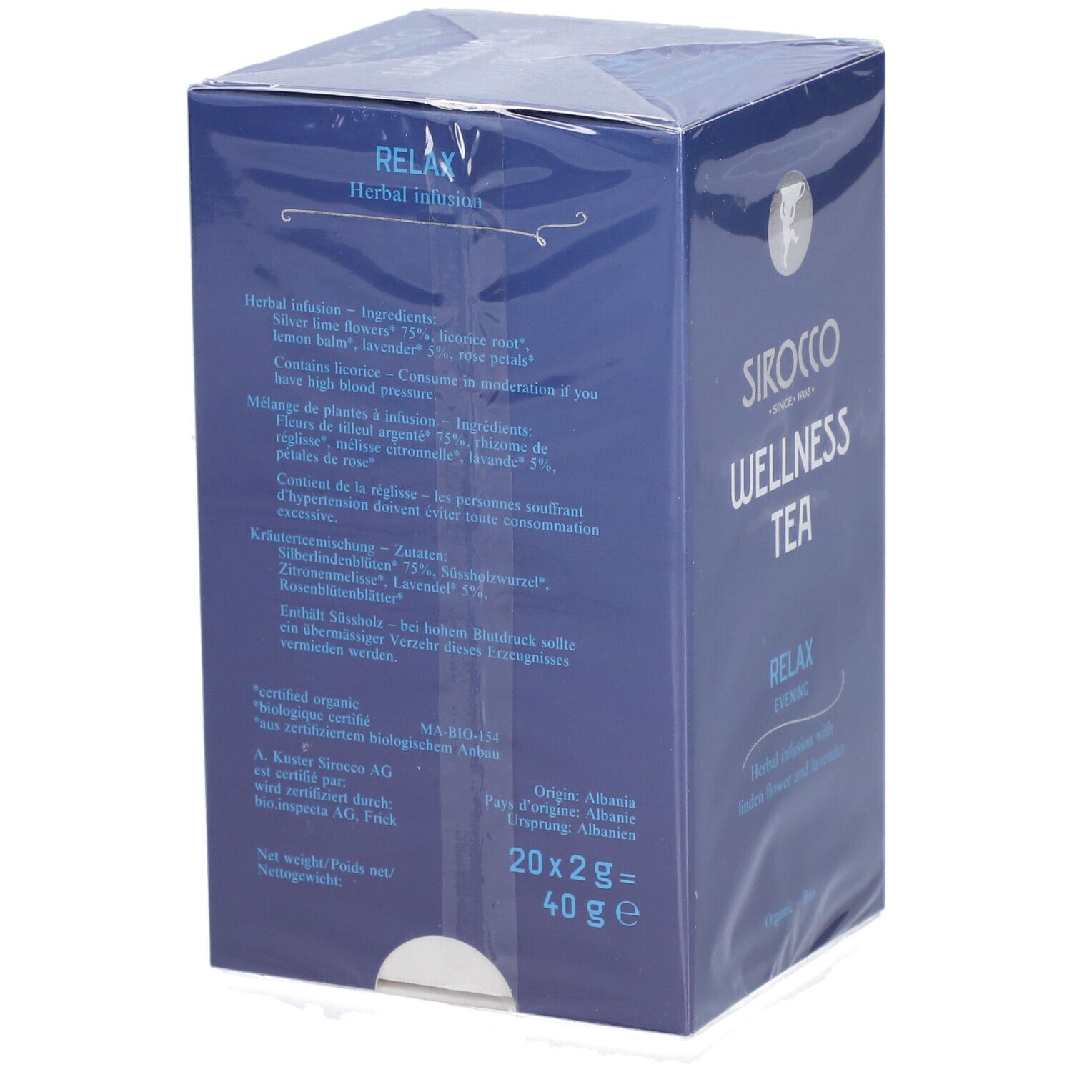 Achterkant van de blauwe doos. Tekst over ingrediënten, instructies en herkomst. "Sirocco Wellness Tea" en "Relax Evening" zichtbaar.