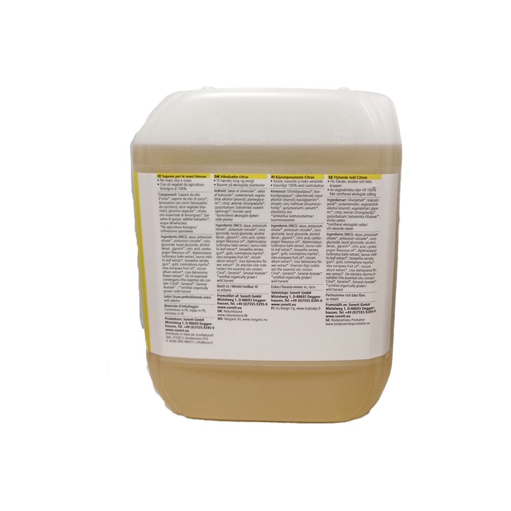 Grand bidon blanc avec liquide jaune et étiquette multilingue.