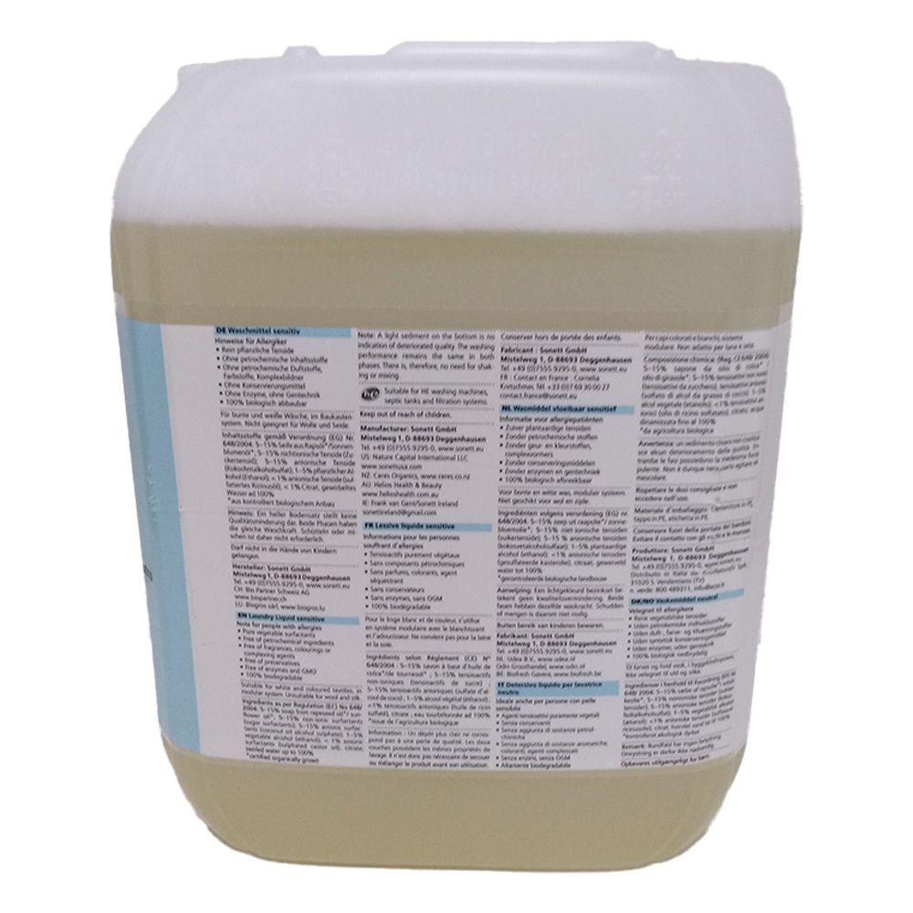 Dos d'un bidon de lessive liquide. Texte multilingue. Bidon blanc avec liquide jaune clair.