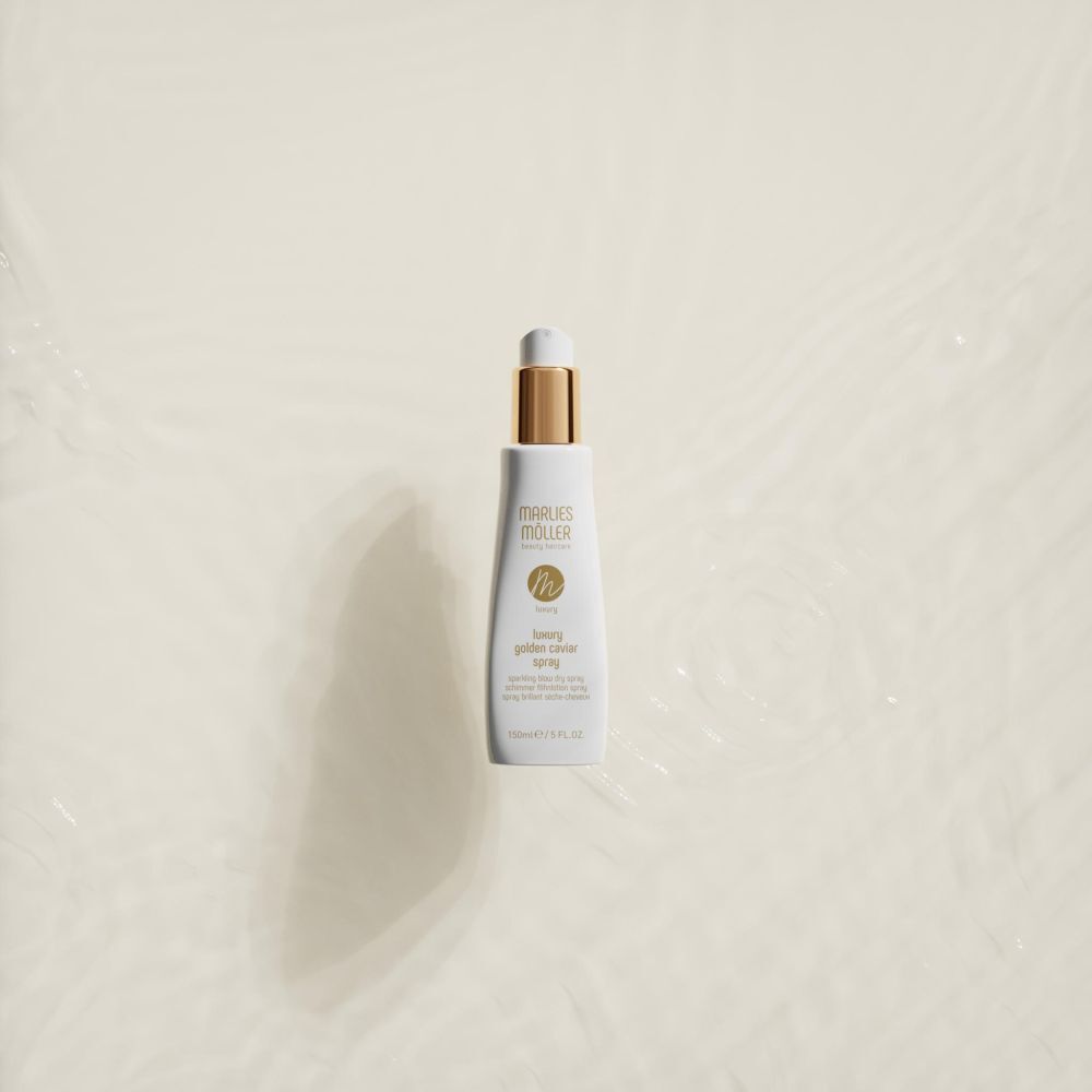 Spray blanc avec bouchon doré dans l'eau. Inscription: Marlies Möller, Luxury Golden Caviar Spray. 150ml/5 FL.OZ.