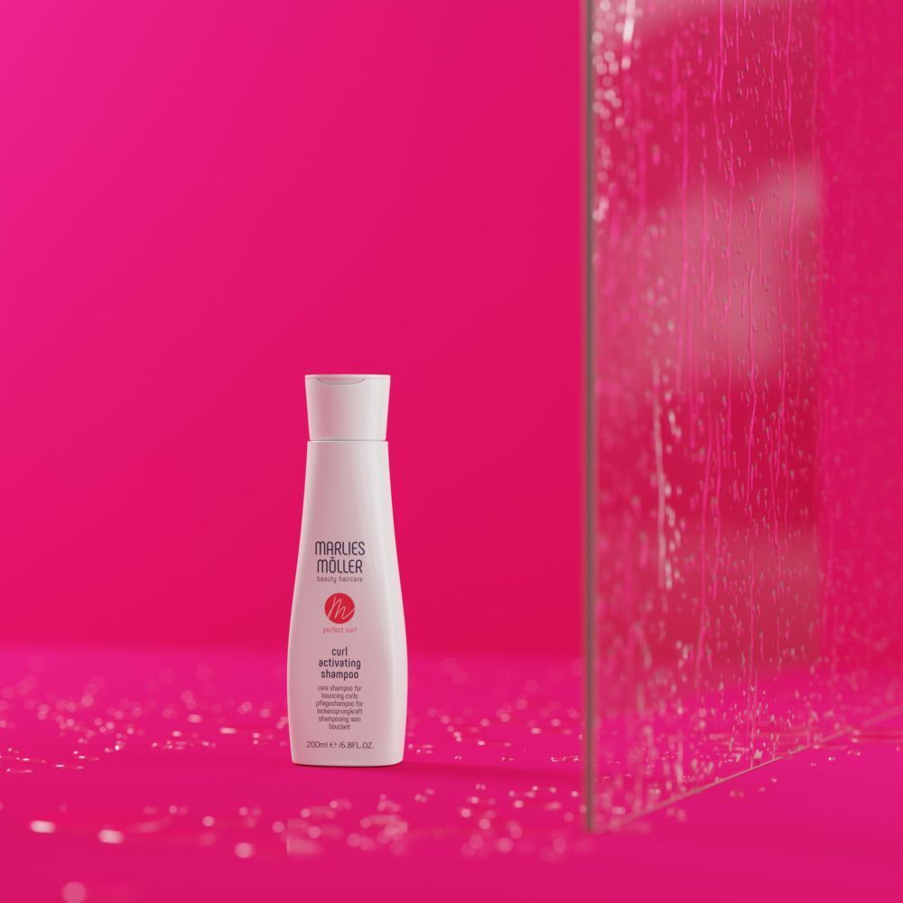 Marlies Möller shampoo fles op roze achtergrond. Productnaam en logo zichtbaar.
