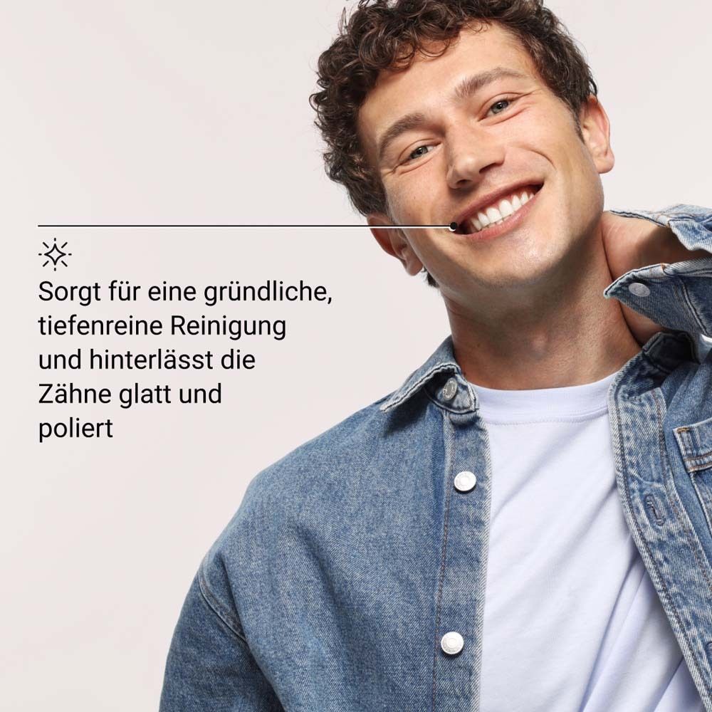 Homme souriant. Texte: Assure un nettoyage en profondeur et laisse les dents lisses et polies.