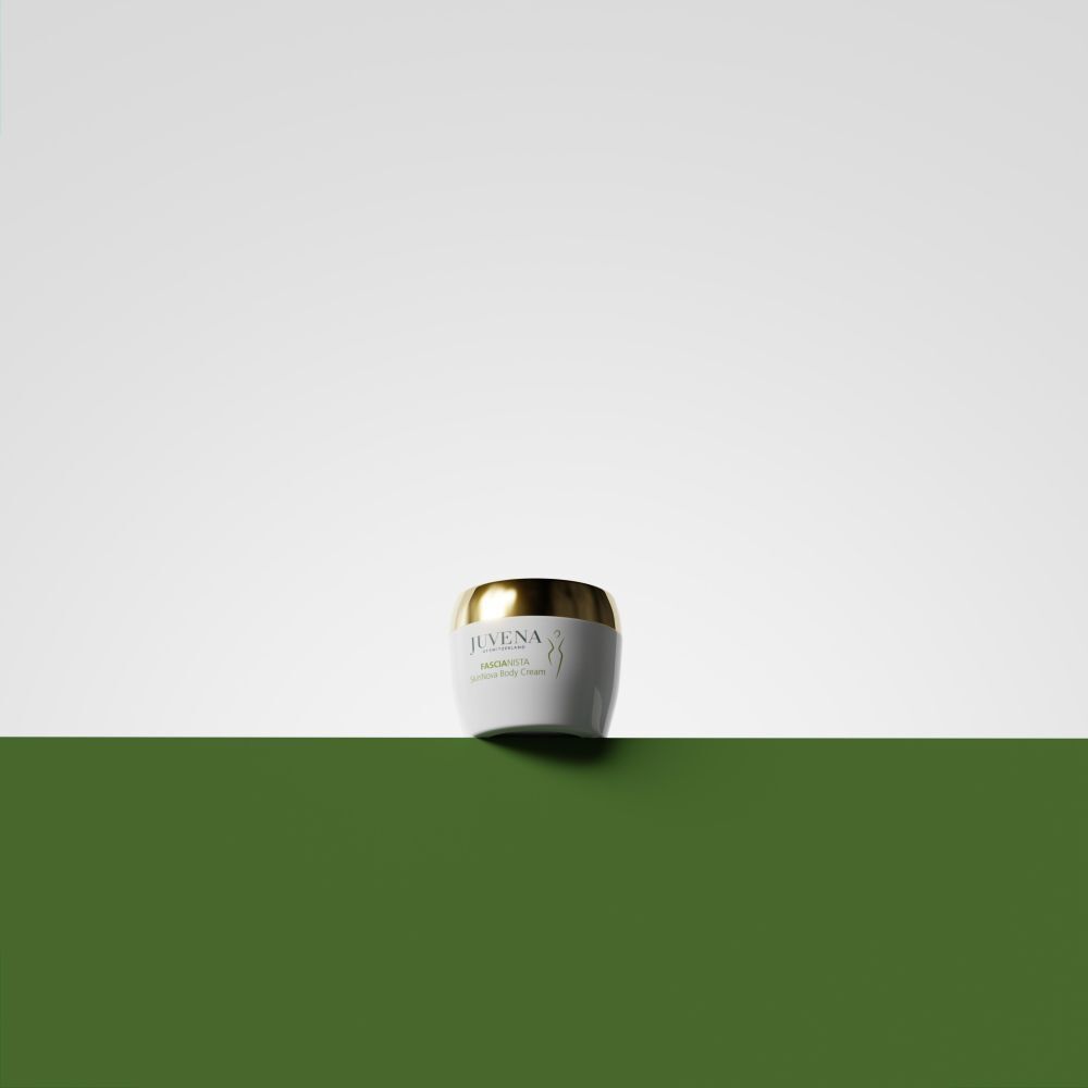 Pot de crème blanc avec couvercle doré sur fond vert. Juvena, Fascionista.