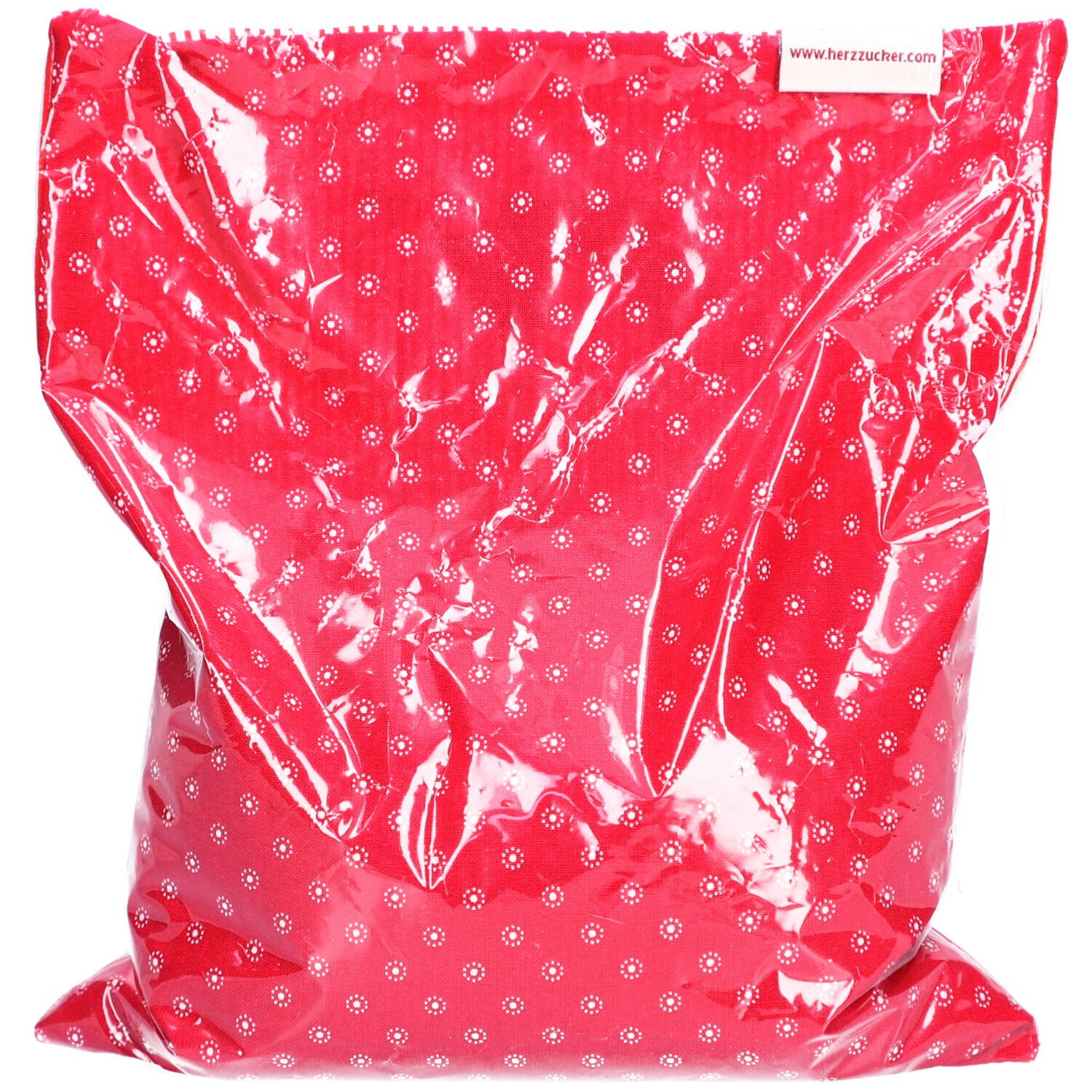 Rood warmtekussen met wit bloemmotief in plastic verpakking. Wit etiket met URL www.herzzucker.ch op de verpakking.