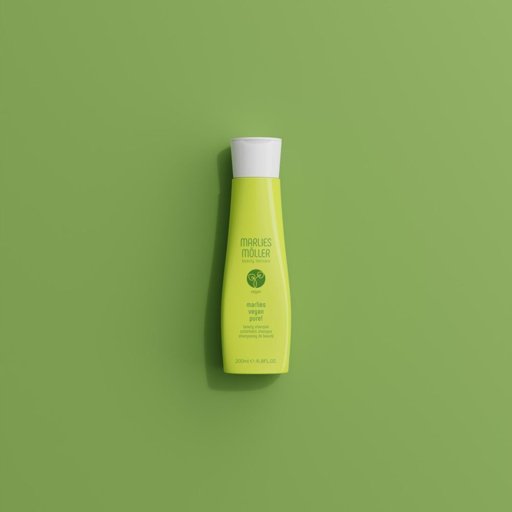 Flacon de shampooing vert sur fond vert. Inscription: Marlies Möller, Vegan Pure! Shampooing.