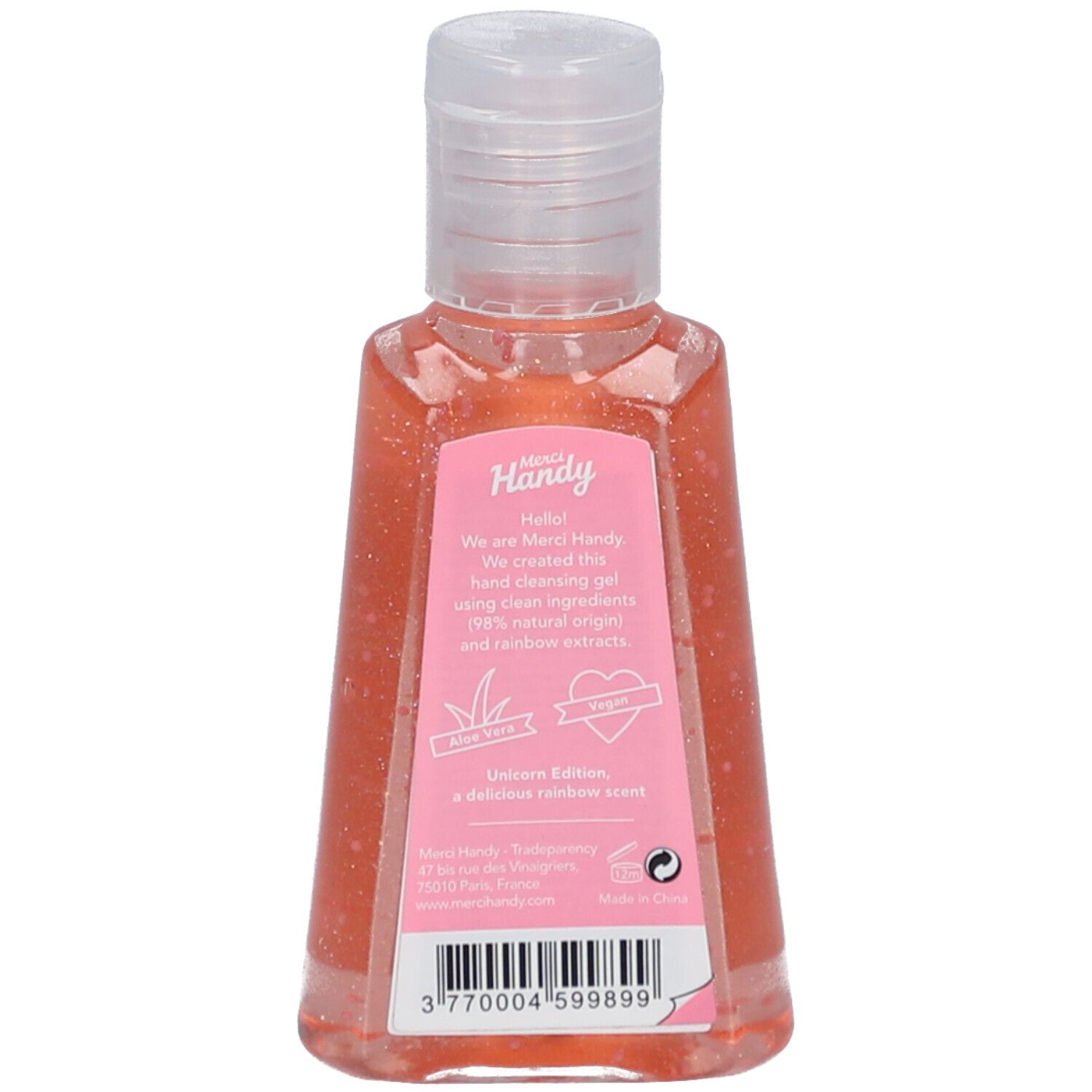 Achterkant van de handreinigingsfles. Roze vloeistof. Tekst op een roze etiket. Logo en tekst Merci Handy.