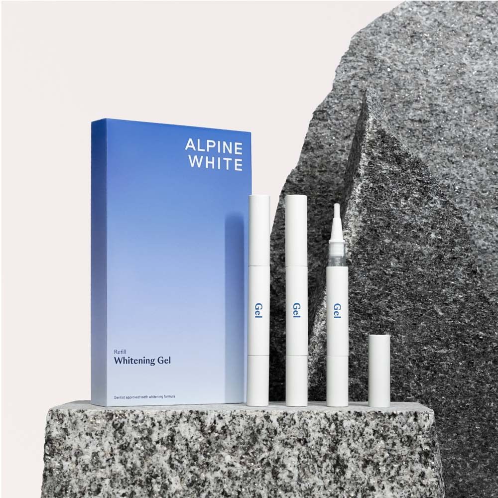Boîte "ALPINE WHITE" et stylos gel. Placé sur des rochers. Stylos gel et emballage.