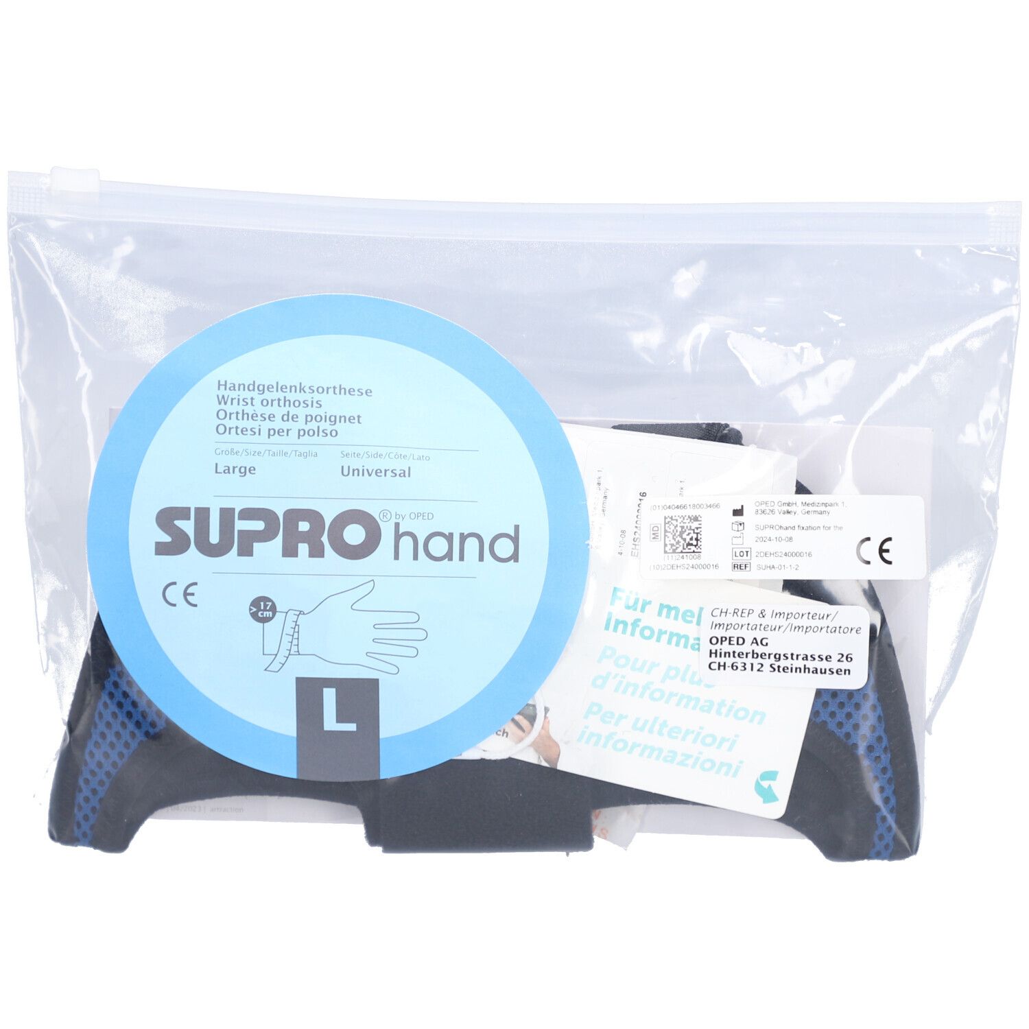 Orthèse de main dans un emballage plastique. Éléments bleus et noirs, carte de produit bleue avec logo et marquage CE. Taille L.