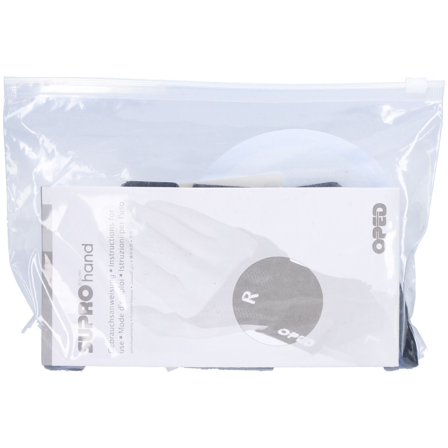Orthèse de main dans un emballage plastique. Contient des instructions et un élément rond. Logo et marquage CE visibles.