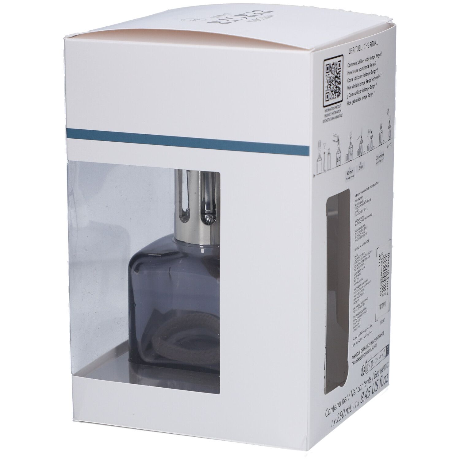 Lampe à parfum dans emballage. Lampe grise, carrée, avec mèche. Emballage blanc avec fenêtre transparente.