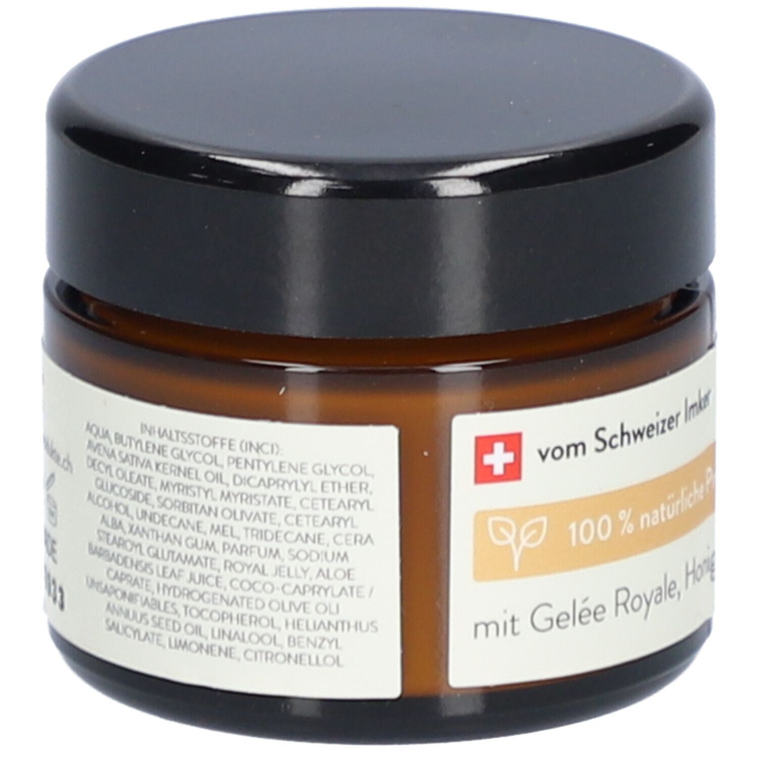 Bruine glazen pot met zwarte deksel. Label met ingrediënten, tekst: van Zwitserse imker, 100% natuurlijk.