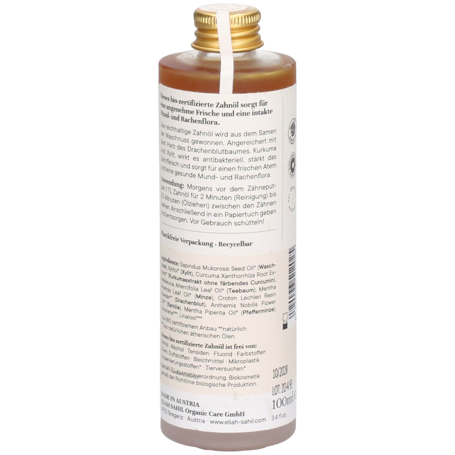 Achterkant van een fles met bruine vloeistof. Etiket met tekst over ingrediënten en gebruik. Gouden dop.