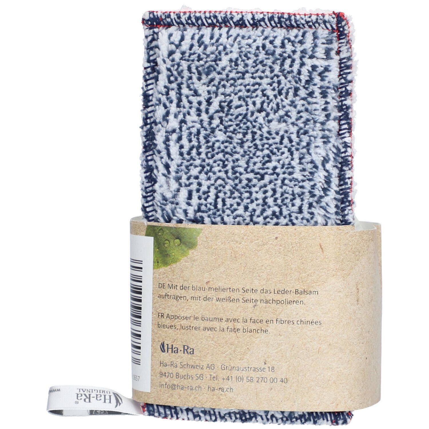 Textielverzorgingsdoek met lederbalsemverpakking. Doek met blauw-wit patroon en rode rand. Verpakking van bruin papier.