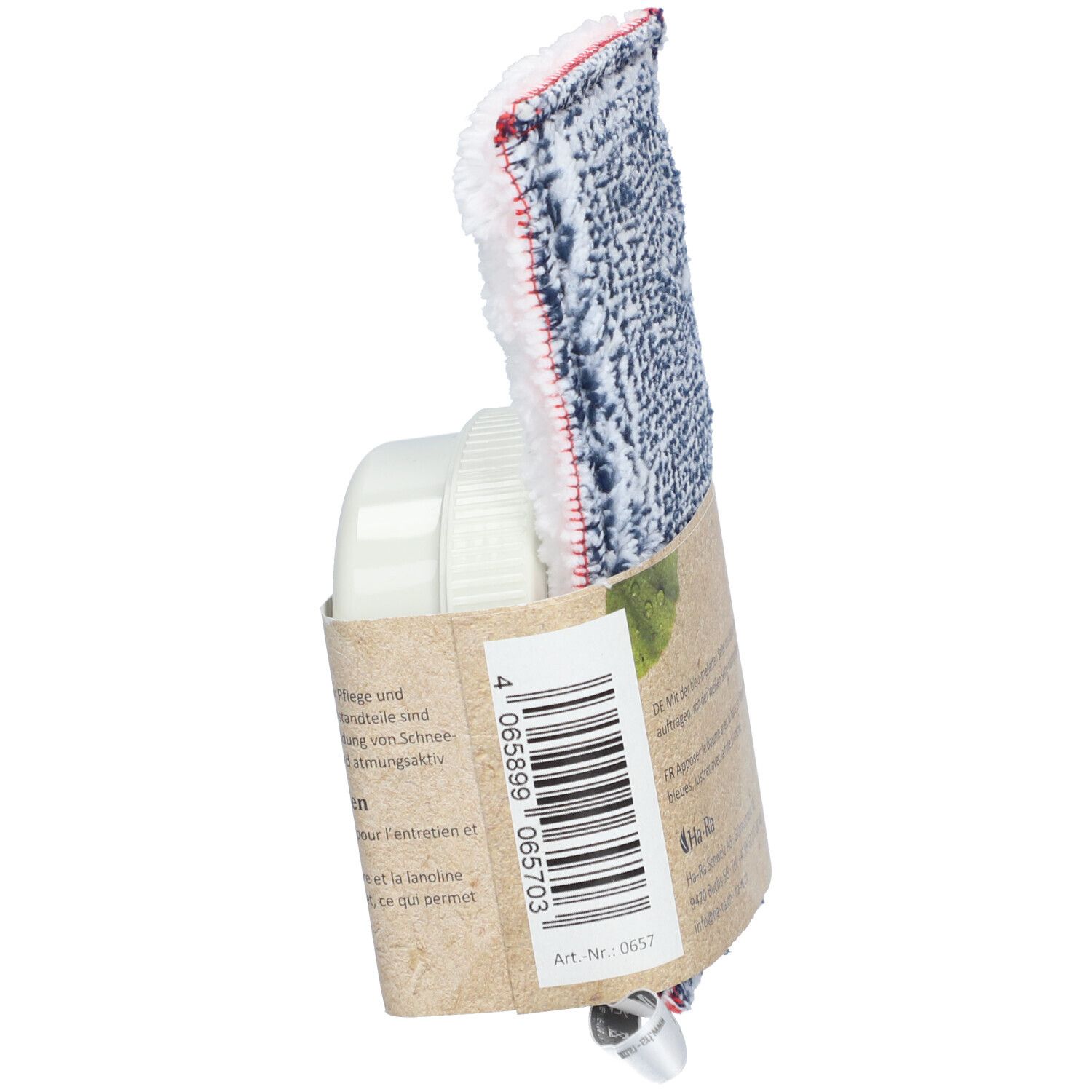 Zijaanzicht van de verpakking met verzorgingsdoek en houder. Doek met blauw-wit patroon en rode rand. Houder en verpakking van papier.